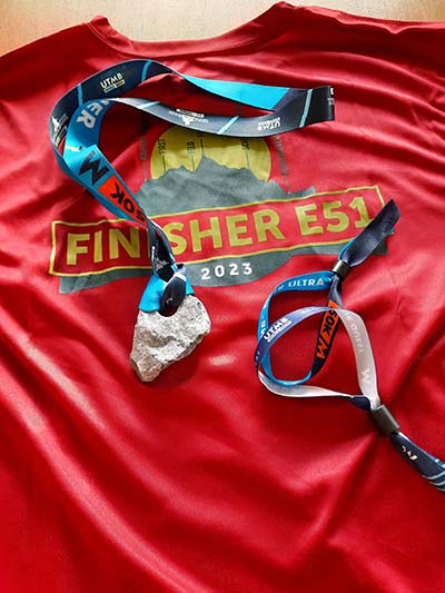 2023 UTMB Eiger E51 Finisher Shirt in red and Finisher Stone (Medal)
